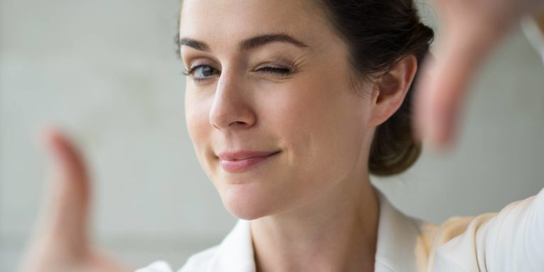 Closeup of Playful Woman Making Frame and Winking