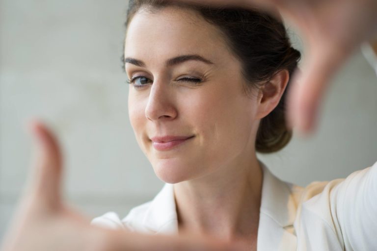Closeup of Playful Woman Making Frame and Winking