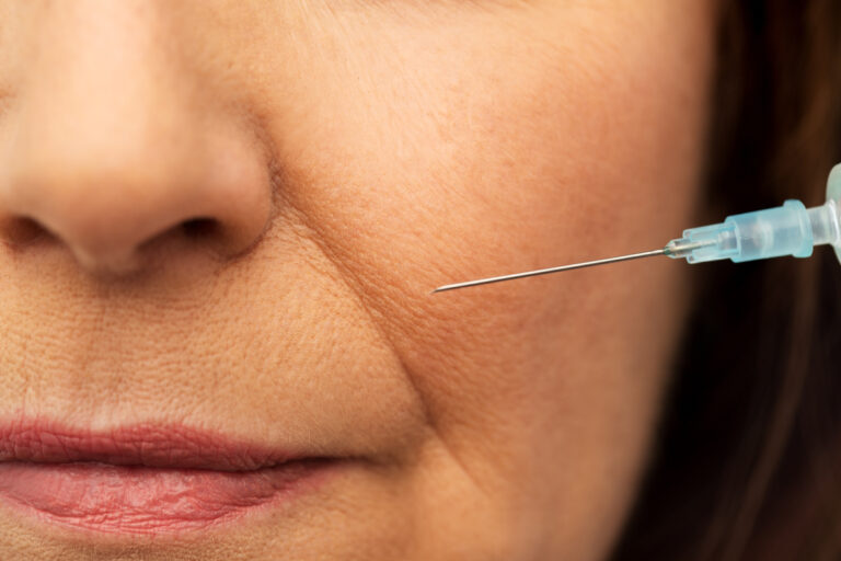 close up of senior woman face and syringe